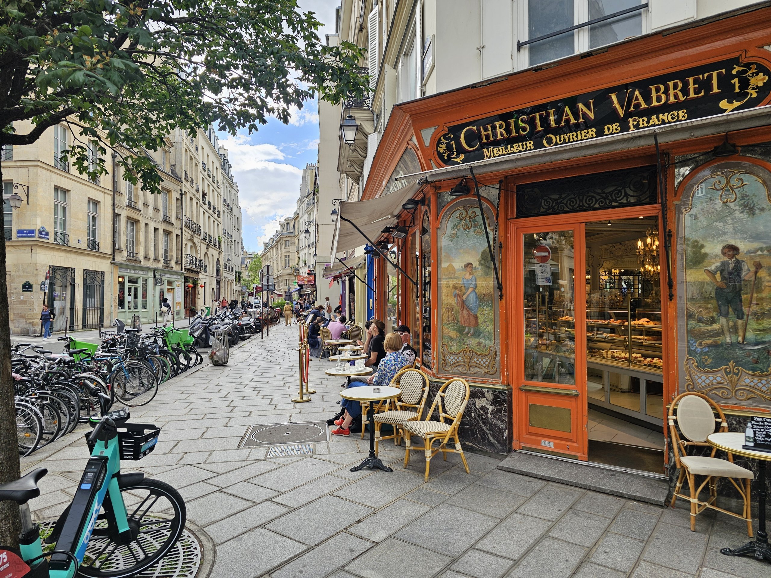 Rua medieval no bairro Le Marais com prédios antigos e calçada de pedras